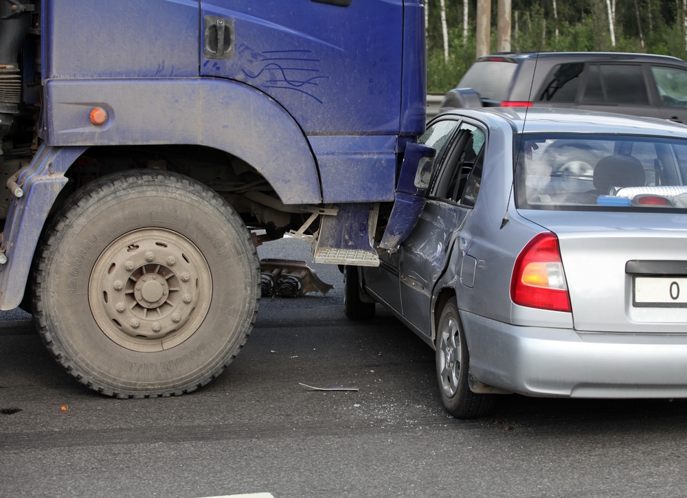 Collision of the truck and car on a busy road